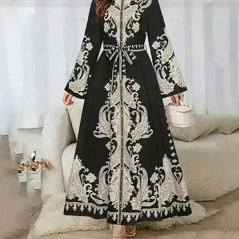 Black Middle Eastern abaya with intricate white embroidery, long sleeves, and belted waist