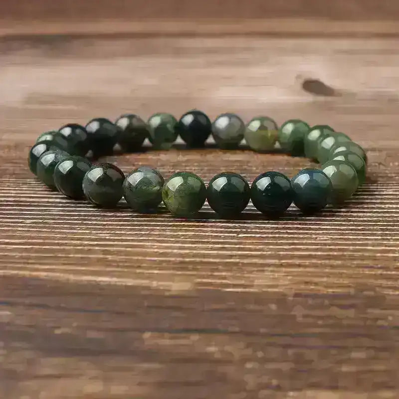 Green natural stone bead bracelet on wooden surface, Middle Eastern accessory