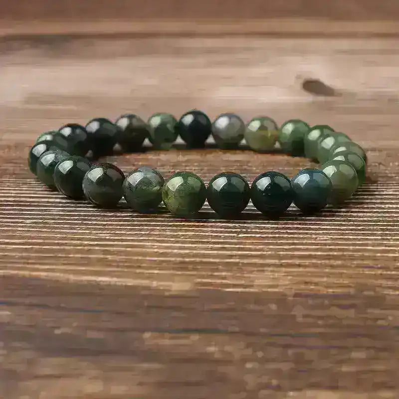 Green natural stone bead bracelet on wooden surface, Middle Eastern accessory