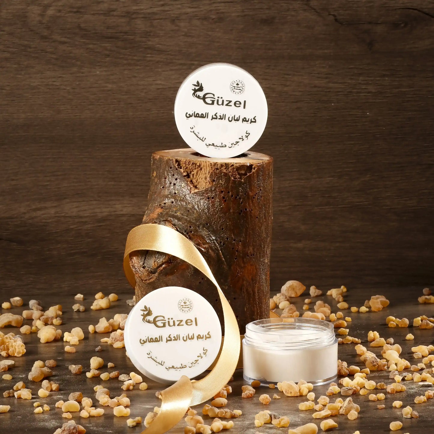 Omani frankincense cream jar with resin pieces, wood background, and gold ribbon