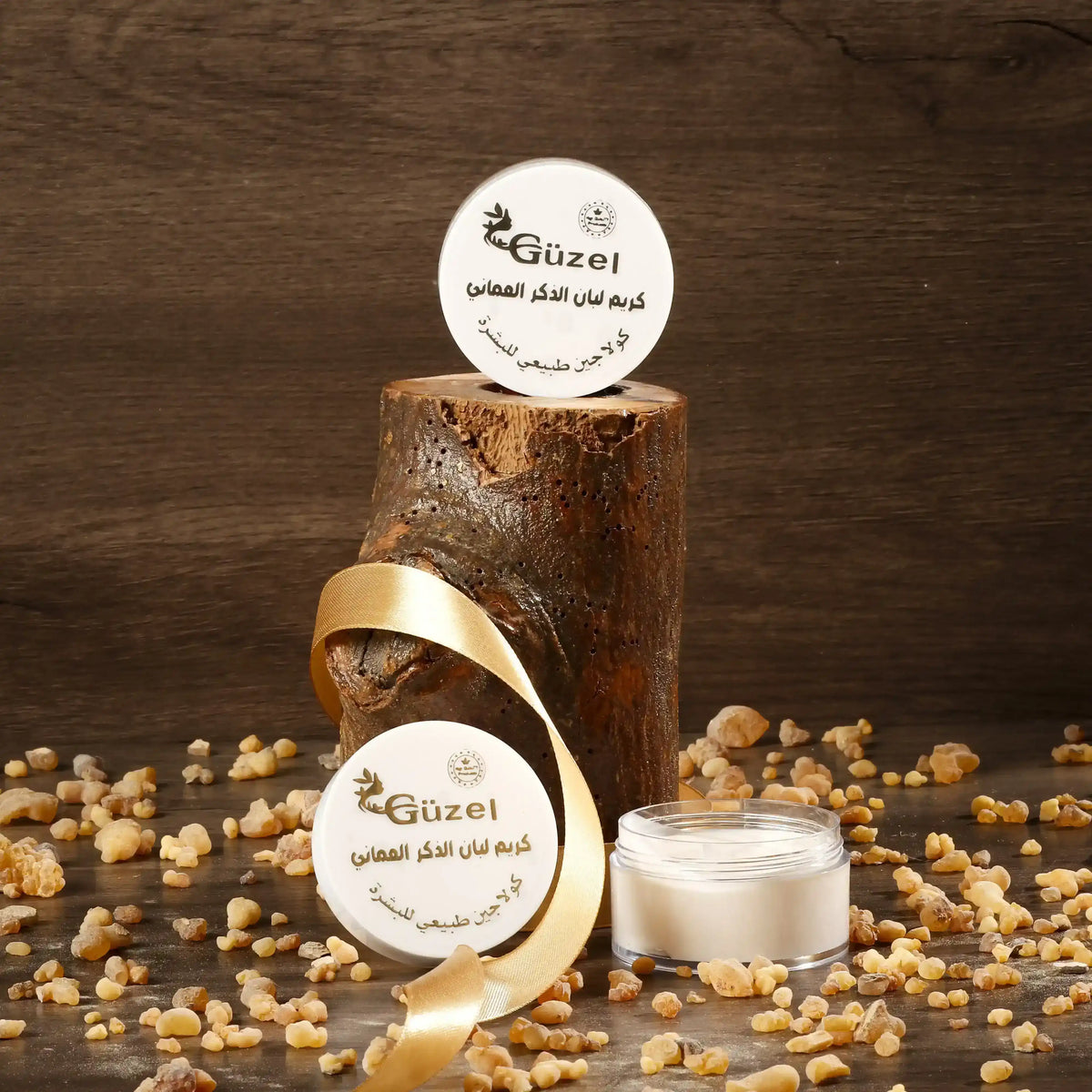 Omani frankincense cream jar with resin pieces, wood background, and gold ribbon