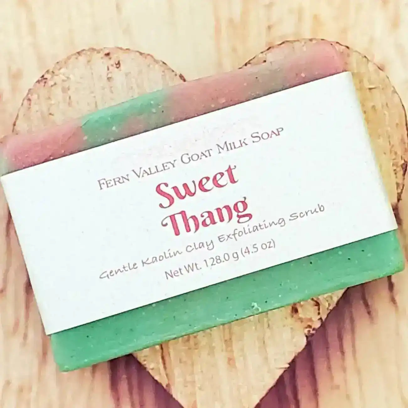 Sweet Thang goat milk soap with gentle kaolin clay exfoliating scrub on wooden surface