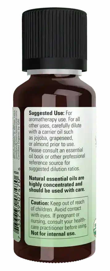 Back label of a brown glass bottle with black cap, showing tea tree essential oil usage instructions, ingredient details, and safety warnings.