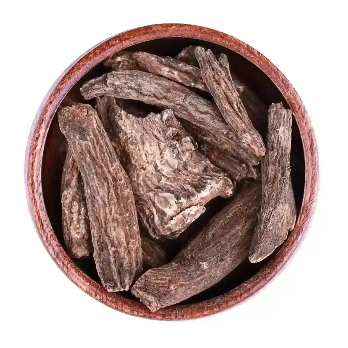 Coarse dried Indian costus roots in a brown wooden bowl on white background