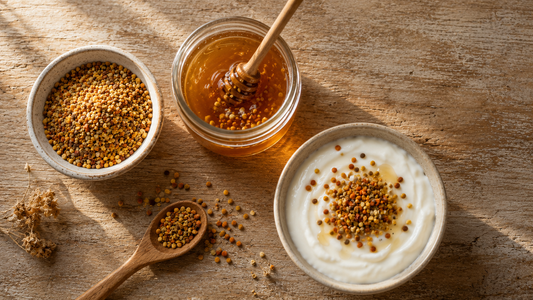 Bowl of multicoloured bee pollen granules with honey being stirred and a bowl of yogurt topped with granules on aged wood
