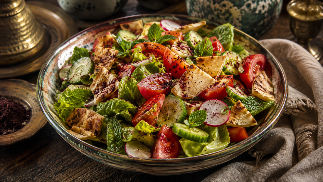 Fresh fattoush salad topped with crisp pita shards, herbs, and a dusting of red sumac.
