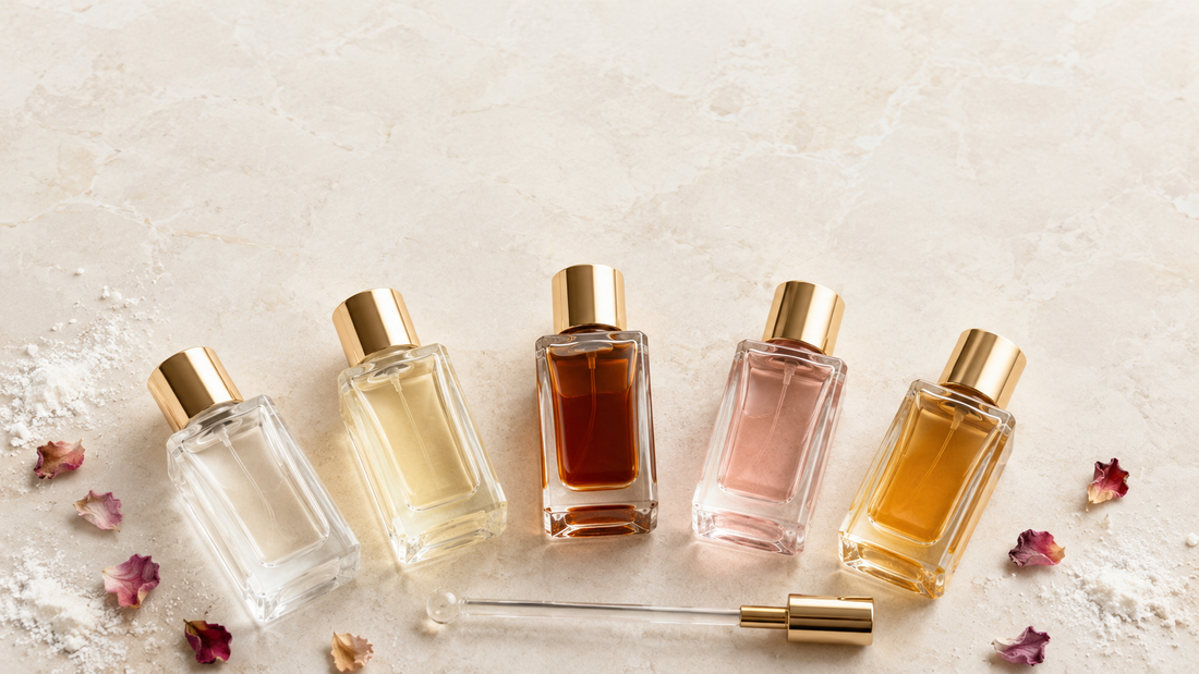 Five Arabic musk perfume oil bottles in varying shades from clear white to deep amber with a glass applicator