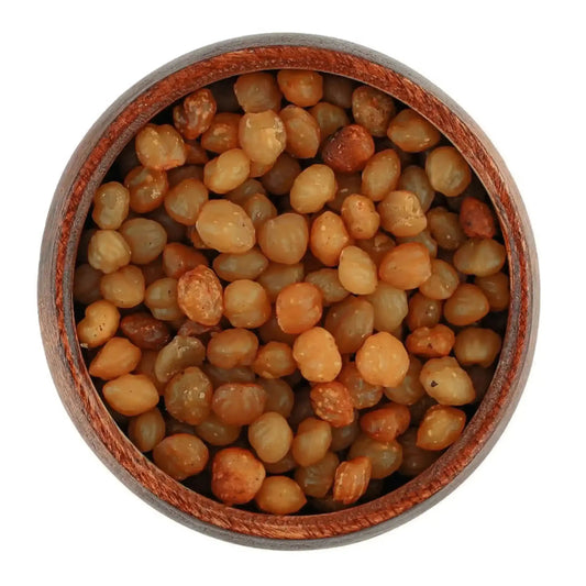 Akpi seeds in a brown wooden bowl on a white background