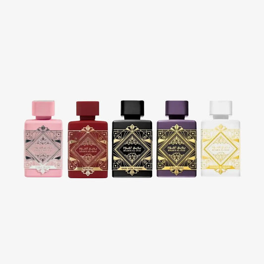 Assorted Middle Eastern perfume bottles with ornate labels in pink, red, black, purple, and white.