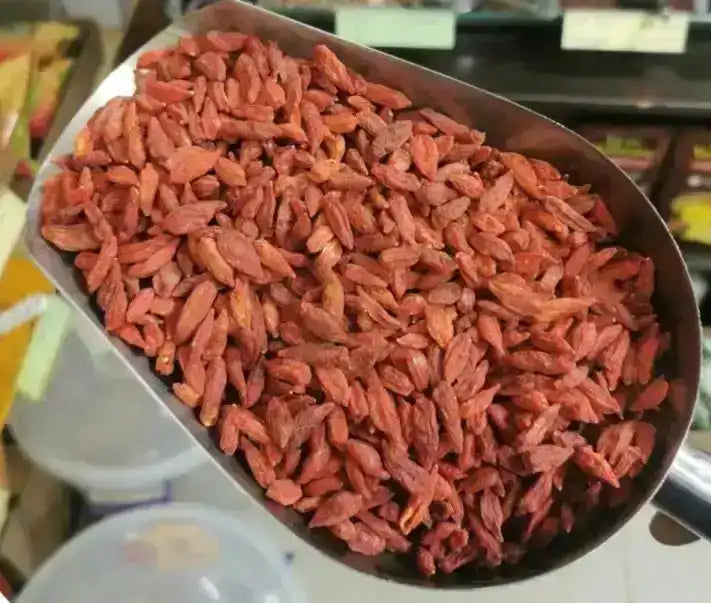 Scoop of dried goji berries in a spice shop setting