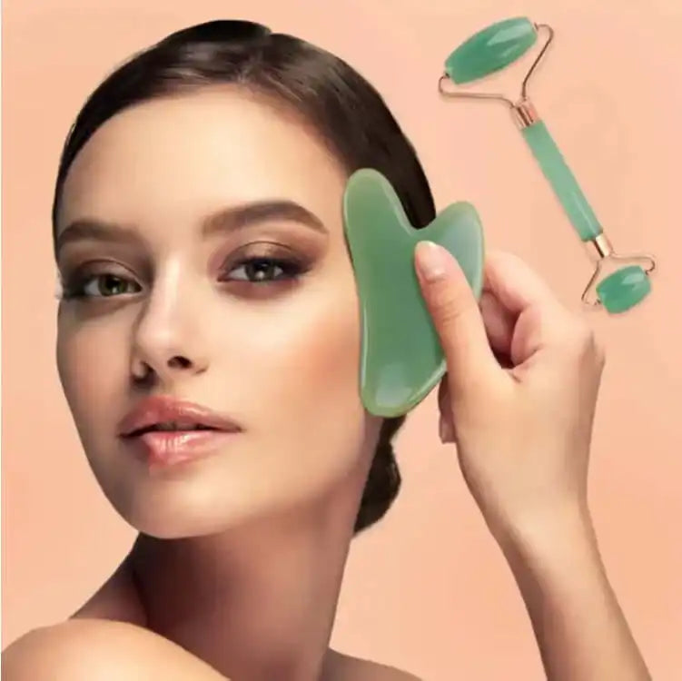 Woman using jade gua sha tool on face with jade roller on peach background