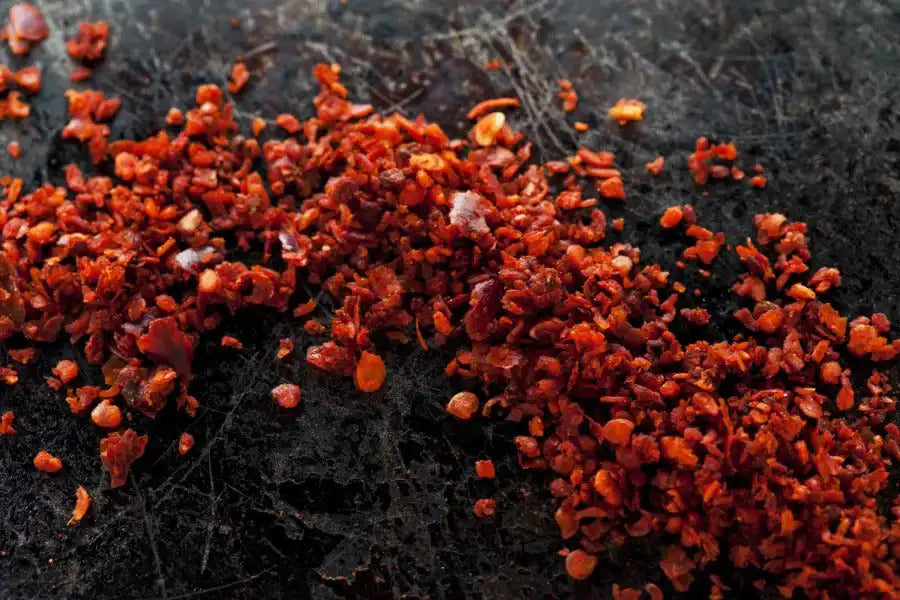 Crushed red chili flakes on dark surface, vibrant Middle Eastern spice for cooking