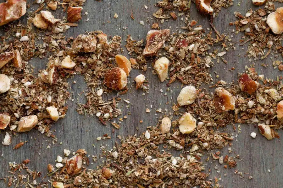 Crushed Middle Eastern spices and nuts on rustic wooden surface