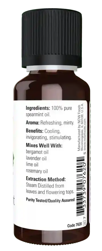 Brown bottle of pure spearmint essential oil with label listing ingredients and uses
