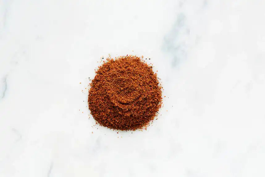Rich red Middle Eastern spice blend on white marble, perfect for authentic cuisine